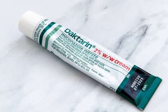 London. UK- January 14.2026. A macro closeup of a used tube of Daktarin Cream for the treatment of skin fungal infections isolated on a white marble background.