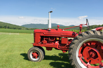 Obraz premium Close-up of an Old Red Tractor in a Country Field