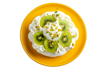 Perfect mini Pavlova cake with whipped mascarpone cream and fresh kiwi slices sprinkled with crushed pistachios on a yellow plate top view isolated on