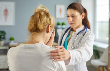A doctor offers support and empathy to a distressed patient in a clinic, providing counseling...