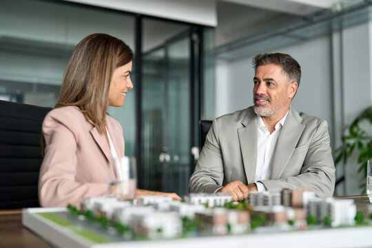 Real estate developers brokers presenting new residential city building development construction luxury housing project architectural model. Investing in realty, bank mortgage loan concept.