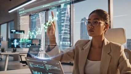 Businesswoman analyzing financial data on futuristic holographic interface in modern office - Powered by Adobe
