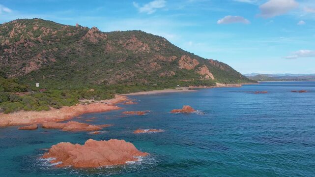 Explore the beautiful Cala E Luas beach in Sardinia from above. The aerial perspective highlights the stunning rocky coastline and sparkling blue waters.