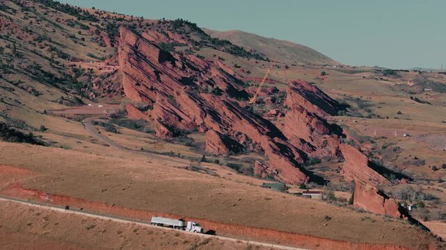 Red Rocks on a sunny day in Colorado with truck passing by on road, aerial video, Denver, Colorado 4K