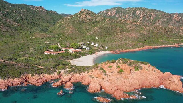 Explore the beautiful Cala E Luas beach in Sardinia from above. The aerial perspective highlights the stunning rocky coastline and sparkling blue waters.