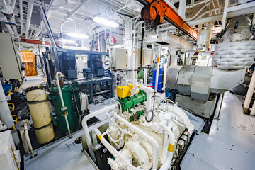 Industrial engine room with pumps, pipes, valves and machinery, showing complex mechanical and...