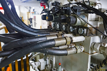Hydraulic control unit with high-pressure hoses, fittings and valves inside an industrial engine...