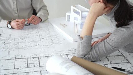 Architects engaging in a design planning meeting, analyzing blueprints and a scale model, making precise measurements and discussing new construction project ideas, close up - Powered by Adobe