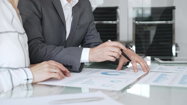Business colleagues discussing financial reports and charts at meeting table, analyzing data for strategizing future projects. Business-people concept