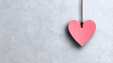 un fondo liso color gris con espacio de copia con un corazon de madera color rosa pastel colgado con un mecate para tarjeta decorativa 