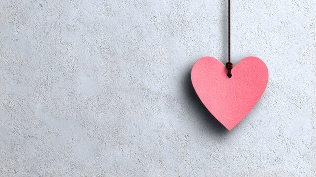 un fondo liso color gris con espacio de copia con un corazon de madera color rosa pastel colgado con un mecate para tarjeta decorativa 