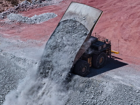 huge caex in the process of dumping rocky material on mine backfill platforms