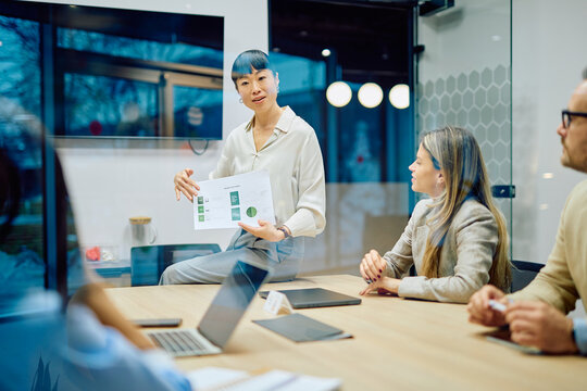 Confident businesswoman presenting charts and graphs to colleagues, discussing strategy and marketing results in an office - Powered by Adobe