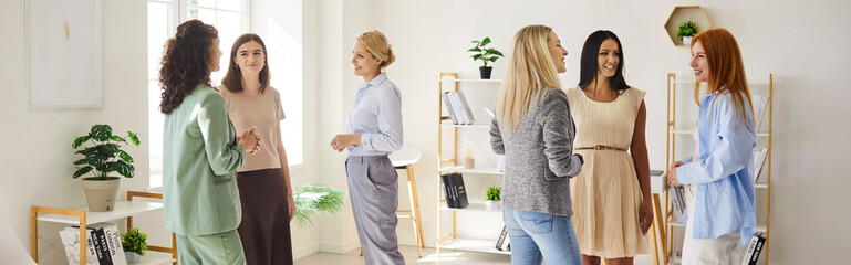 Women team meeting during collaborative training workshop. In a bright studio, a diverse group discusses ideas and practices coaching. Concept: teamwork, learning, and female leadership.