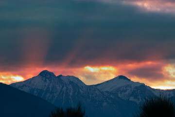 Obraz premium Pindus mountains in Greece with snow. Sunbeams at sunset. Red and orange sky. Beautiful destination for travel.