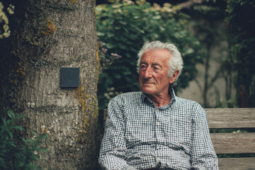 Elderly Man Sitting Peacefully On Garden Bench