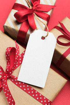 Blank gift tag wrapped presents with red ribbons and decorative patterns on a vibrant background, ideal for holiday giftings and personal messages