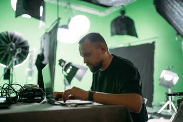 Editing director behind monitors on the set. A video editor edits video online while filming for a...