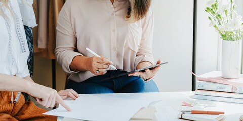 Two stylist women colleagues working together for new project. This scene captures collaboration,...