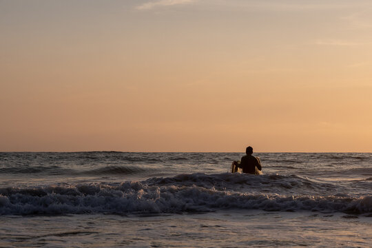 Fisherman throwing a cast net or atarraya at the seashore with water at his waist. Artisanal fishing with a throw net. costalegre