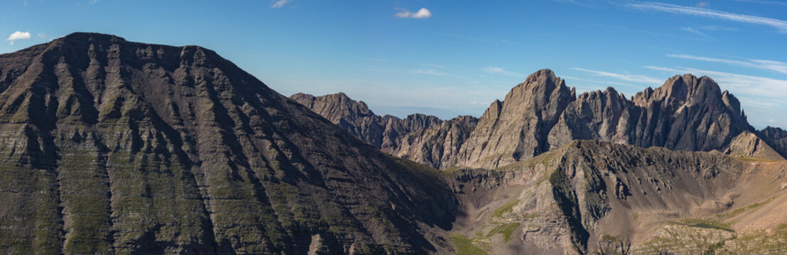 This zoomed in mountain panorama features Colorado Sangre de Cristo Range 14ers Humboldt Peak, Crestone Peak, and Crestone Needle under a blue sky.