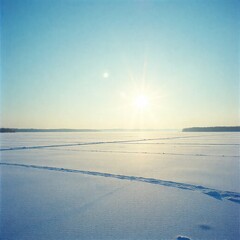 Minimal winter solstice landscape, snow plain with low sun and clear sky, calm and empty space