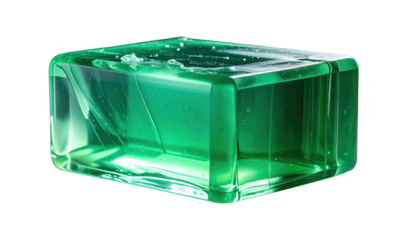 A translucent, emerald-green, rectangular block reflects light and shows internal fractures