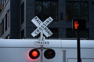 Sound transit light rail commuter train crossing, railroad crossing sign, white X, multiple tracks, yield to train red light flashing, transportation background
