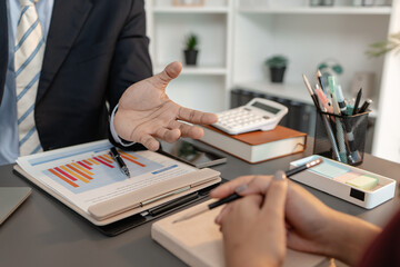 A collaborative startup meeting showing professionals reviewing financial charts and discussing strategic ideas in a modern office setting.