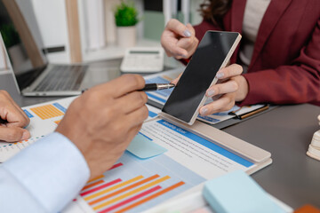 Business colleagues reviewing budget charts together in a modern office, focusing on financial...