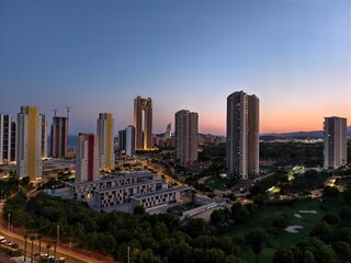 Fototapeta premium colorful coastal sunset skyline, tranquil sunset over housing towers and vibrant horizon silhouettes