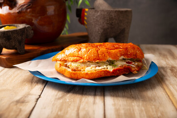 Pambazos. Mexican sandwich marinated in red sauce and roasted on a comal traditionally stuffed with potatoes and chorizo, a classic of Mexico City street food.