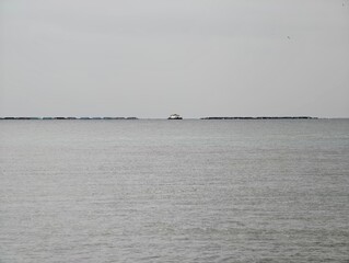 Naklejka premium Serene landscape of distant maritime refuge, Sparse horizon view suggesting navigation and longing mood