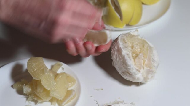 Close up of hands meticulously peeling grapefruit segments and removing pith for a fresh, healthy and delicious fruit, perfect for a balanced diet, wellness routine and culinary experience.
