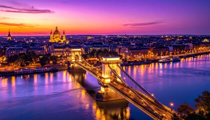 Obraz premium Panoramic view of Budapest cityscape with Chain Bridge at dusk, reflecting vibrant orange-purple sunset on Danube River, in a serene and picturesque artistic style