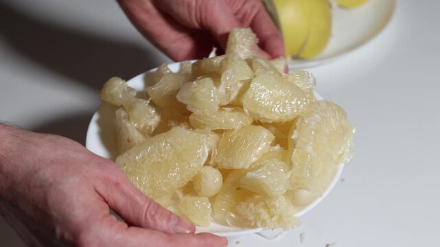 A close-up of a plate with fresh pomelo segments, showing the juicy texture and highlighting its refreshing nature, symbolizing healthy eating habits, perfect fruit snack preparation.