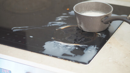 Boiling milk spills on stovetop during cooking time