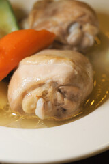 Chicken dish with vegetables on a white plate