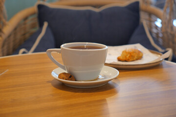 Coffee and cookie on a table in a cozy cafe setting