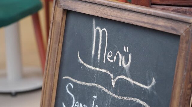 Menu board at an outdoor cafe in the afternoon sun