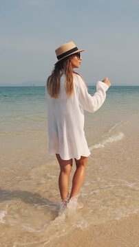 Summer trip to islands, slender female tourist walking aeon on ocean coastline and admiring unique landscape. Caucasian traveler woman exploring amazing nature of asia, warm waves of sea and sand