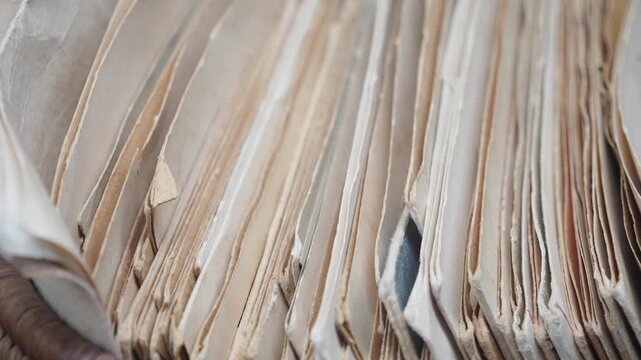 Old papers stacked on a shelf in a study room
