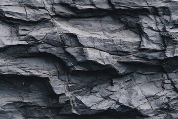 Close Up of Dark Wet Rock Formation with Jagged Edges and Rough Texture Under Natural Light in Outdoor Setting Showing Geological Details