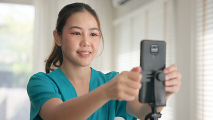 Young adult woman asia Gen Z people anti aging expert modern nurse live talk prepare video selfie camera on mobile phone app mental health care Online side hustle digital virtual asian vlogger filming