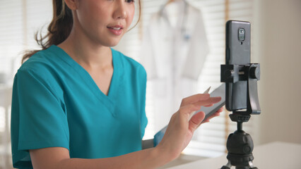 Young adult woman asia Gen Z people anti aging expert modern nurse live talk prepare video selfie camera on mobile phone app mental health care Online side hustle digital virtual asian vlogger filming