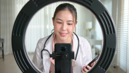 Young adult woman Gen Z asia people anti aging expert modern nurse live talk viral video selfie camera on mobile phone app mental health care. Online sharing digital virtual asian vlogger filming.