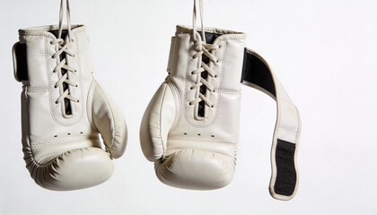 White boxing gloves hanging from strings on clean background