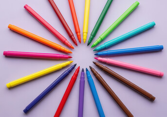 Naklejka premium Colorful marker pens arranged in a symmetrical circular pattern on pastel background forming creative art design and vibrant educational stationery concept