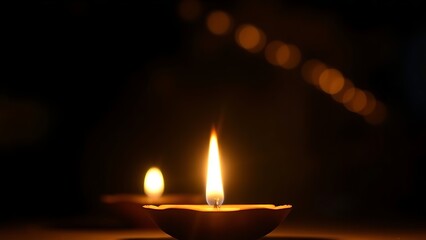 Golden diya glowing in darkness, symbolizing tradition and festive spirit in Indian culture.