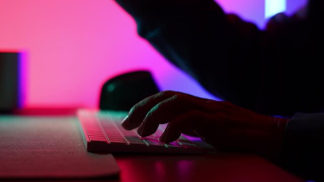 Closeup hand cyber crime. Senior man hacker hacking computer. anonymous hacker wearing black hoodie in dark room. online scam and cyber security threat.